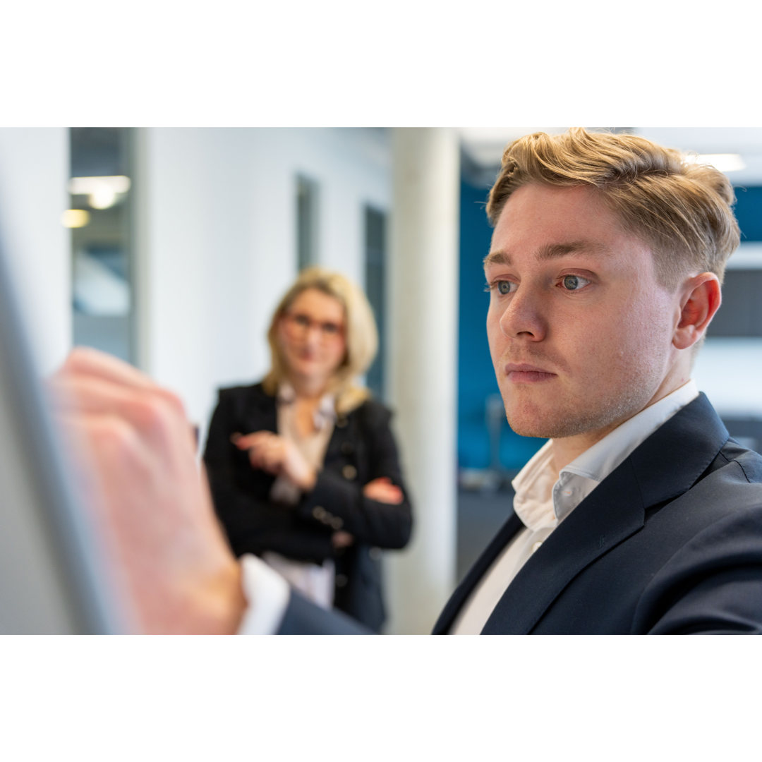 Maximilian Keppler schreibt konzentriert an ein Whiteboard. 